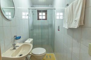 a bathroom with a sink and a toilet and a mirror at Pousada do Marquinhos in Trindade +23 photos