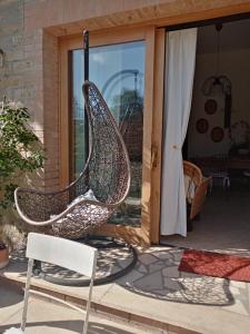 uma cadeira de baloiço num pátio com uma janela em Garma em Murlo
