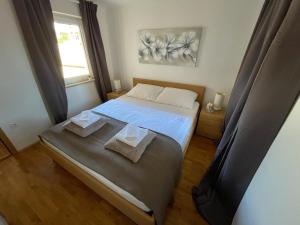 a bedroom with a bed with two towels on it at Apartman Rosi in Dramalj