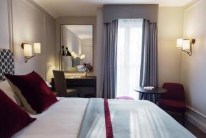 a hotel room with a bed and a desk and a mirror at Old Parsonage Hotel in Oxford