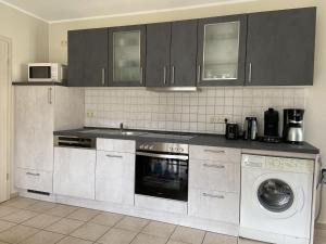 a kitchen with a stove and a dishwasher at Ferienwohnung Strandidyll in Strandnähe in Trassenheide