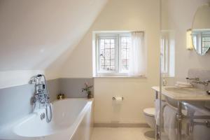 a bathroom with a tub and a toilet and a window at Old Parsonage Hotel in Oxford