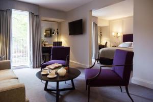 a hotel room with a bed and a table and chairs at Old Parsonage Hotel in Oxford