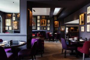 a restaurant with tables and chairs and pictures on the walls at Old Parsonage Hotel in Oxford