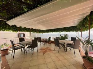 a patio with tables and chairs under a white umbrella at Casa di Nives in Krk