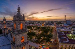 a clock tower in a city at sunset at HIT Merida Hotel Boutique in Mérida