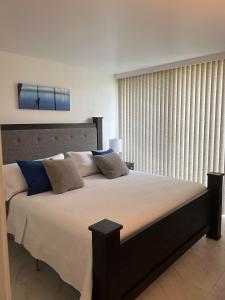 a bedroom with a large bed with a large window at Cozy & Peaceful North Shore Oasis at Turtle Bay in Kahuku