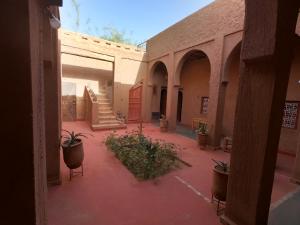 a courtyard with potted plants and stairs in a building at Authentic riad & activities Erg in Mhamid