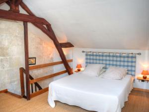 a bedroom with a large white bed with two lamps at Gîte Cheillé, 2 pièces, 3 personnes - FR-1-381-417 in Cheillé