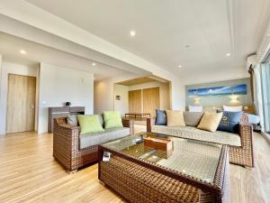 uma sala de estar com dois sofás e uma mesa em Coral Palace Onna by Sunset Avenue em Onna
