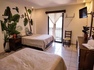 a hotel room with two beds and a balcony at Hotel CaféNaranja Xilitla in Xilitla