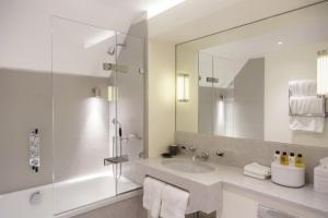 a white bathroom with a sink and a mirror at Old Parsonage Hotel in Oxford