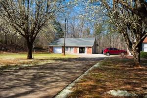 ein Haus mit einem roten Auto, das davor geparkt ist in der Unterkunft A Peaceful Hidden Treasure in Oxford GA in Conyers