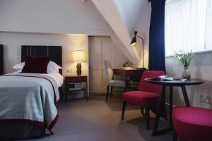 a bedroom with a bed and a table and a desk at Old Parsonage Hotel in Oxford