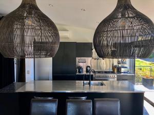 a kitchen with two hanging pendant lights over a counter at Remarkable Escape for 8 in Queenstown