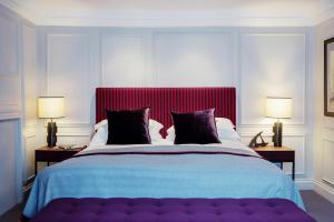 a bedroom with a large bed with a red headboard at Old Parsonage Hotel in Oxford