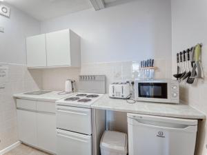 a white kitchen with a stove and a microwave at Apartment 5 - 1 Bedroom Sea Front-Sea Views-Free Parking in Paignton +11 photos