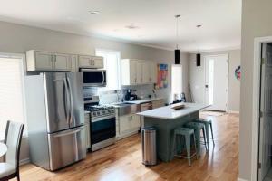 a kitchen with stainless steel appliances and wooden floors at Atlanta Unit 1 Room 1 - Peaceful Private Master Bedroom Suite with Private Balcony in Atlanta
