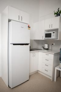 a white refrigerator freezer sitting in a kitchen at Great Keppel Island Hideaway in Great Keppel