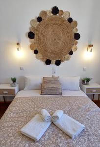 a bedroom with a bed with two towels on it at Casa di Syrii in Ermoupoli