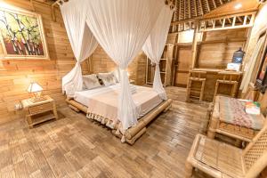 sypialnia z łóżkiem z moskitierą w obiekcie Bamboo Bungalows w mieście Nusa Lembongan