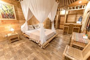 ein Schlafzimmer mit einem Bett mit Moskitonetz in der Unterkunft Bamboo Bungalows in Nusa Lembongan