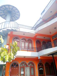 um edifício laranja com janelas e uma varanda em Paramount guest house em Pokhara