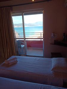sypialnia z łóżkiem i widokiem na ocean w obiekcie maria corfu apartments w mieście Mesongi