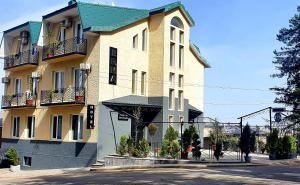 un gran edificio amarillo con techo verde en Erma, en Telavi