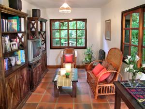 a living room with chairs and a tv and a table at Posada La Escondida in Villa General Belgrano