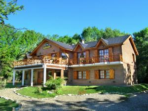 a large wooden house with a large deck at Posada La Escondida in Villa General Belgrano