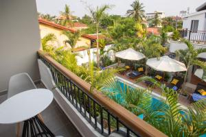 a balcony with a view of a pool and palm trees at Cambana La Rivière Hotel in Battambang