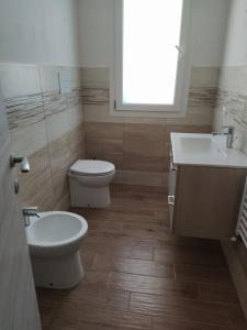 a bathroom with a toilet and a sink and a window at casaaugello in Menfi