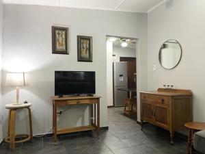 ein Wohnzimmer mit einem Flachbild-TV und einem Tisch in der Unterkunft Umlalazi Cottage in Mtunzini