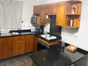 a kitchen with wooden cabinets and a stove top oven at Umlalazi Cottage in Mtunzini