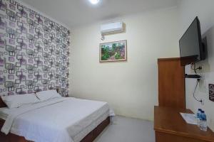 Tempat tidur dalam kamar di RedDoorz at Tanakatto Homestay Waikabubak