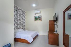 A bed or beds in a room at RedDoorz at Tanakatto Homestay Waikabubak