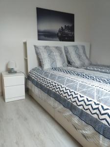 een slaapkamer met een bed met een nachtkastje en een foto bij Au calme sur le port de plaisance et le GR34 in Plérin