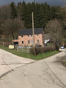 una vieja casa de ladrillo al lado de una carretera en « En toute simplicité chez Fabienne et Bruno », en Waimes