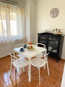 a white table and chairs with a bowl of fruit on it at Apartman Rosi in Dramalj