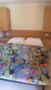 a bed with a colorful blanket on top of it at Sunshine SH apartmanház in Zamárdi