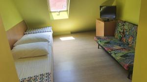 a small room with a bed and a couch at Sunshine SH apartmanház in Zamárdi