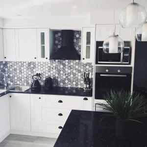 a kitchen with white cabinets and a black stove top oven at 67 Whale Rock Estate, Hermanus in Hermanus