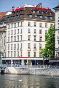 a large white building next to a river at The Ambassador in Geneva