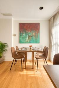 a dining room with a table and chairs and a painting at Casa Asturias in Ensenada +86 photos
