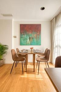 a dining room with a table and chairs and a painting at Casa Asturias in Ensenada