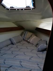 uma cama na parte de trás de um barco com uma janela em Voilier de charme à quai em Saint-Raphaël