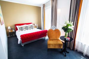 a bedroom with a red couch and a red chair at The Ambassador in Geneva
