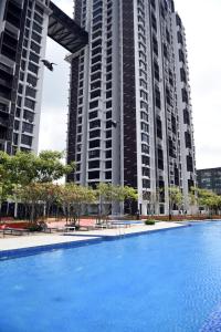 史里肯邦安的住宿－Mines Astetica Lake View Condo Seri Kembangan v1，两个高楼前的游泳池