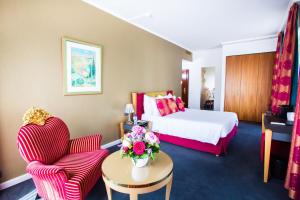 a hotel room with a bed and two chairs at The Ambassador in Geneva